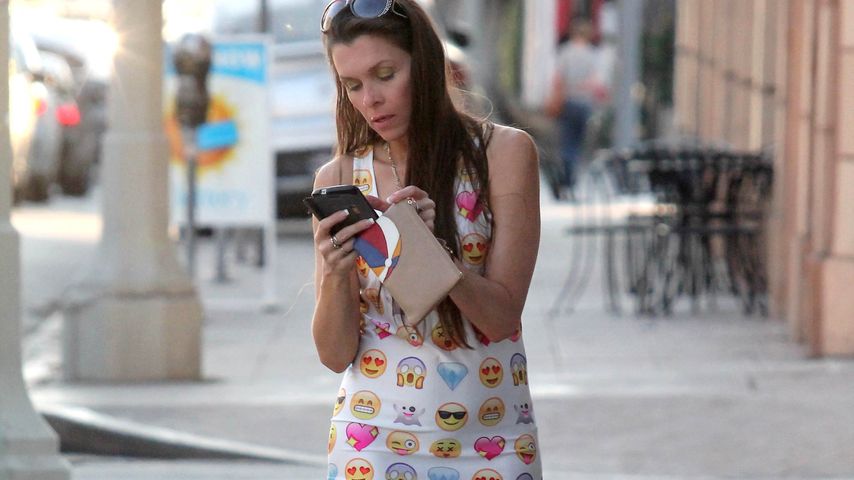 Alicia Arden tippt auf ihrem Handy in Hollywood