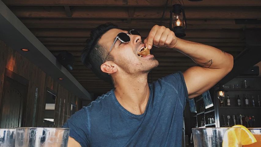 Joe Jonas vor einem Tisch voll Fast Food