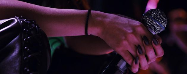 Selena Gomez' Hände mit einem Mikrofon in der Hand Selena Gomez' Hände mit einem Mikrofon in der Hand